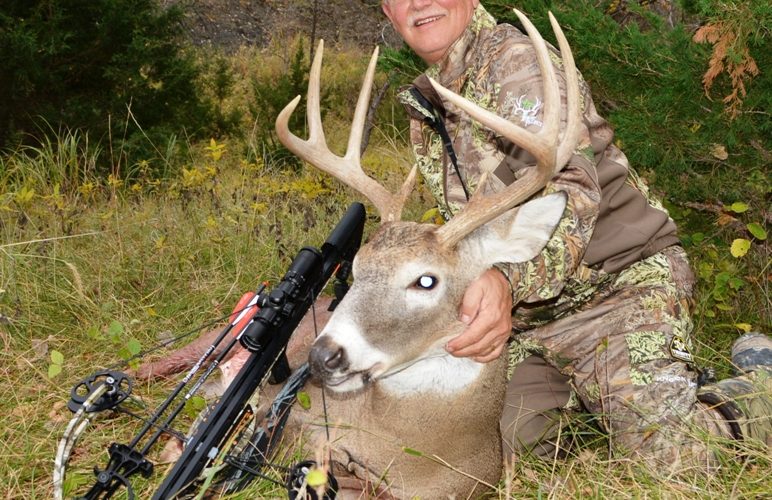 Image of a larger buck, hunter, and his crossbow