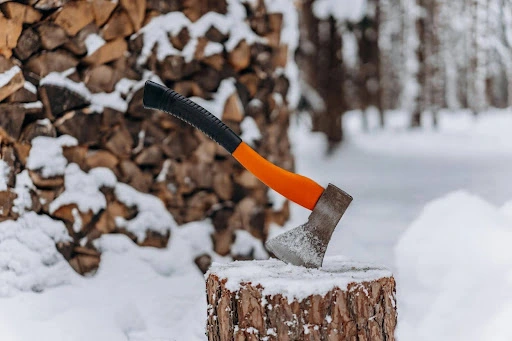 A winter scene with snow and an axe in a stump